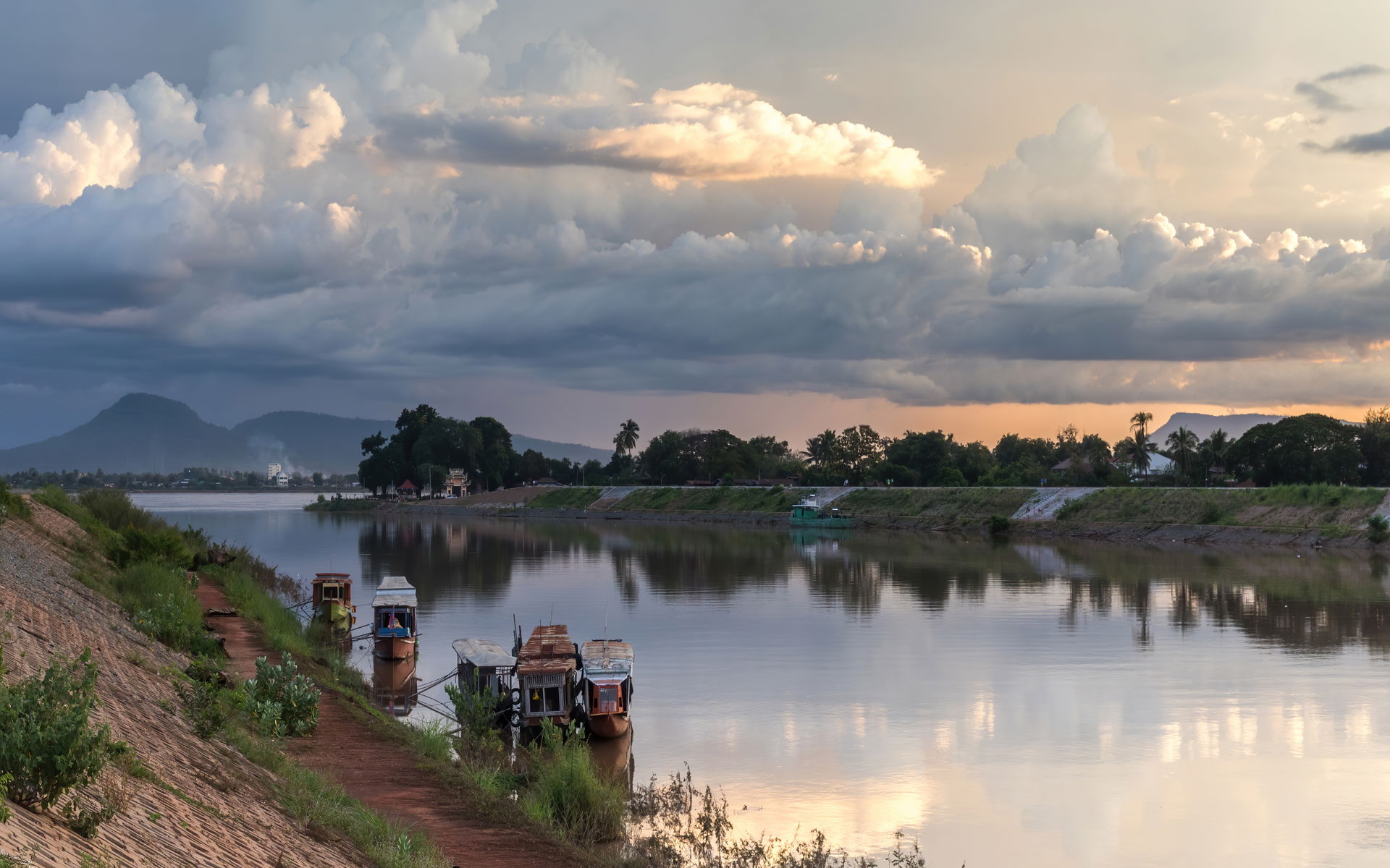 Clouds over the Xe Don River with boats at sunset in Pakse, in …