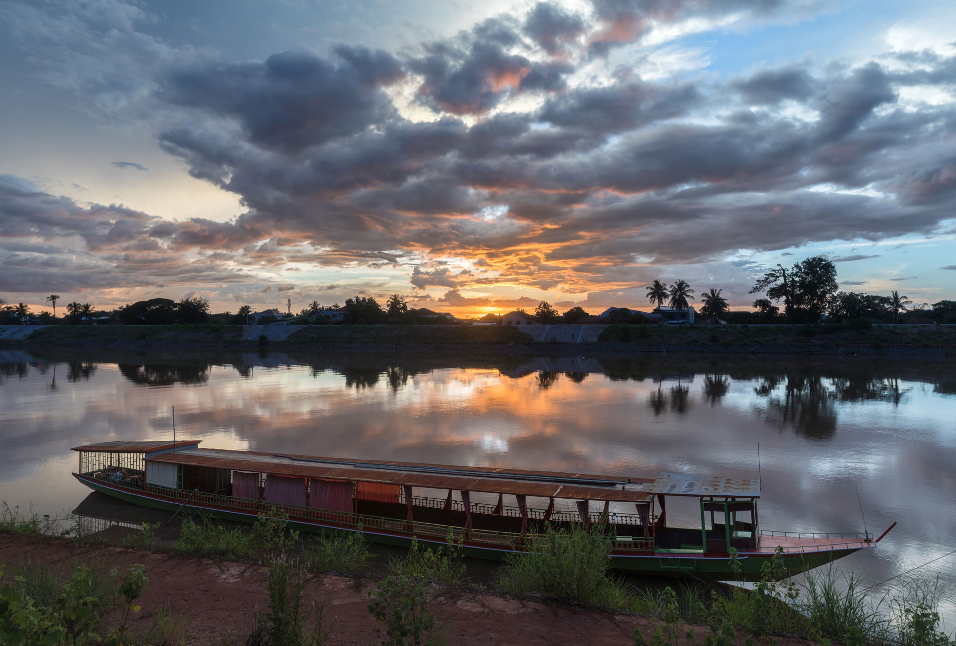 Water reflection of sunset with gray and orange clouds over the…