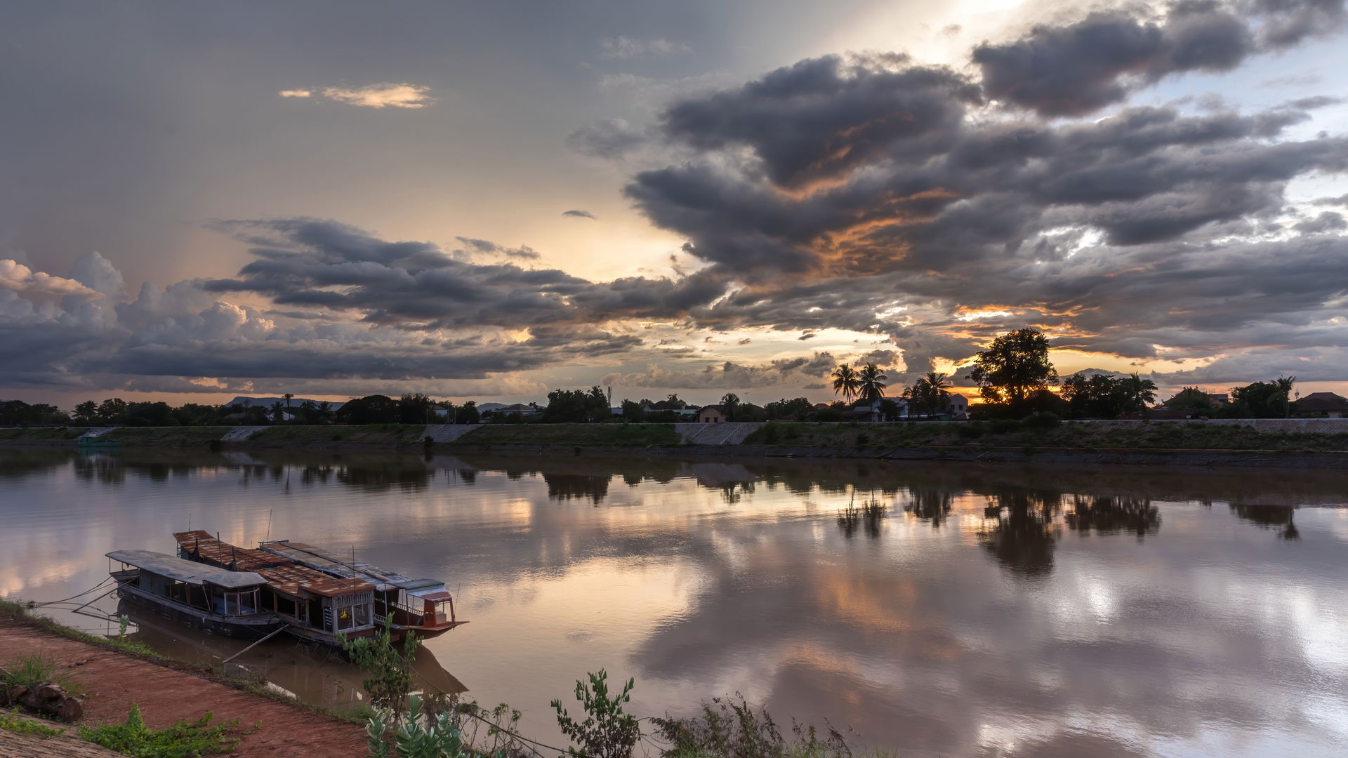 Water reflection of sunset with gray and orange clouds over the…