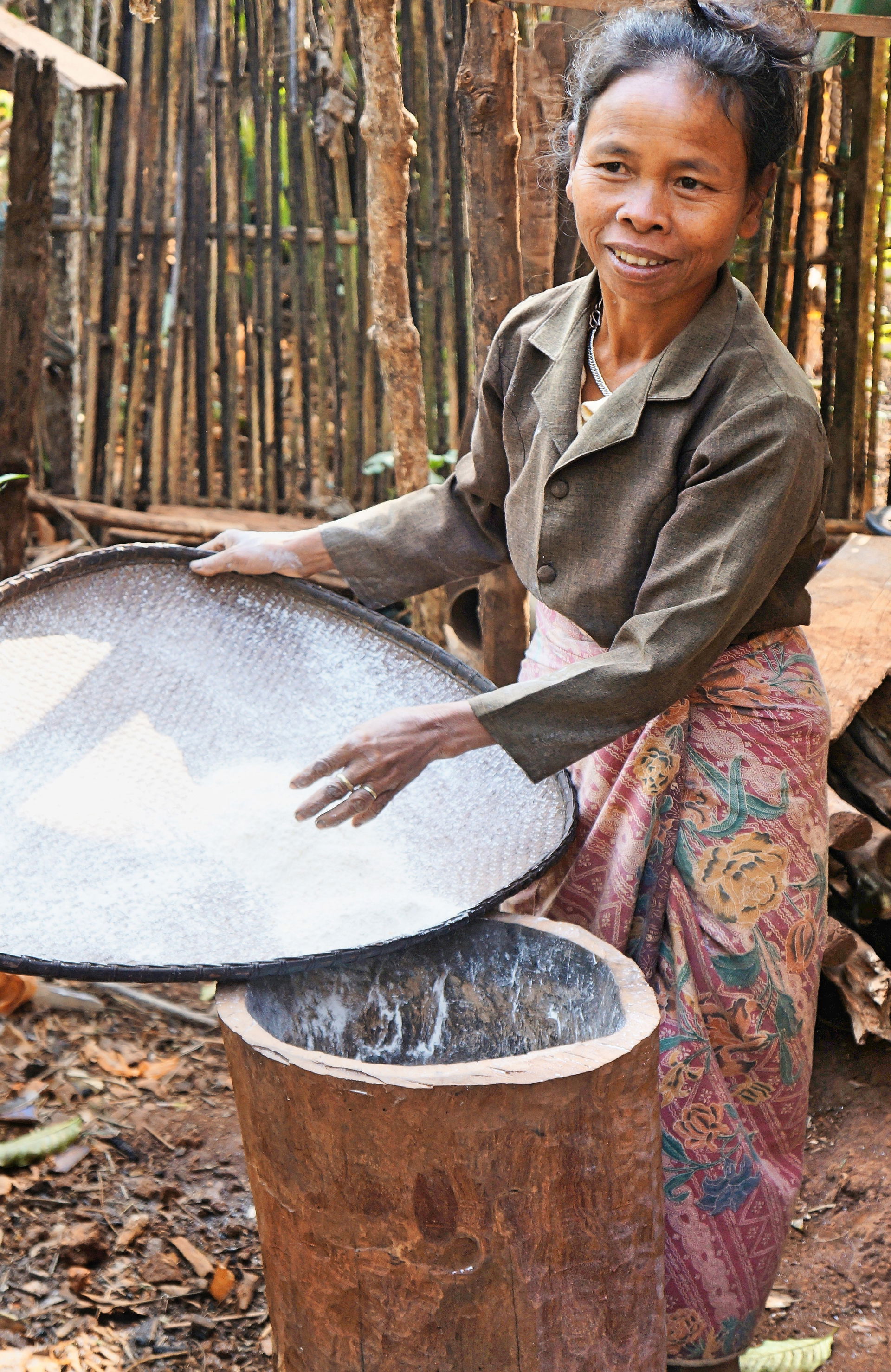 Villager sieving  cereals to make flour in Model healthy villag…