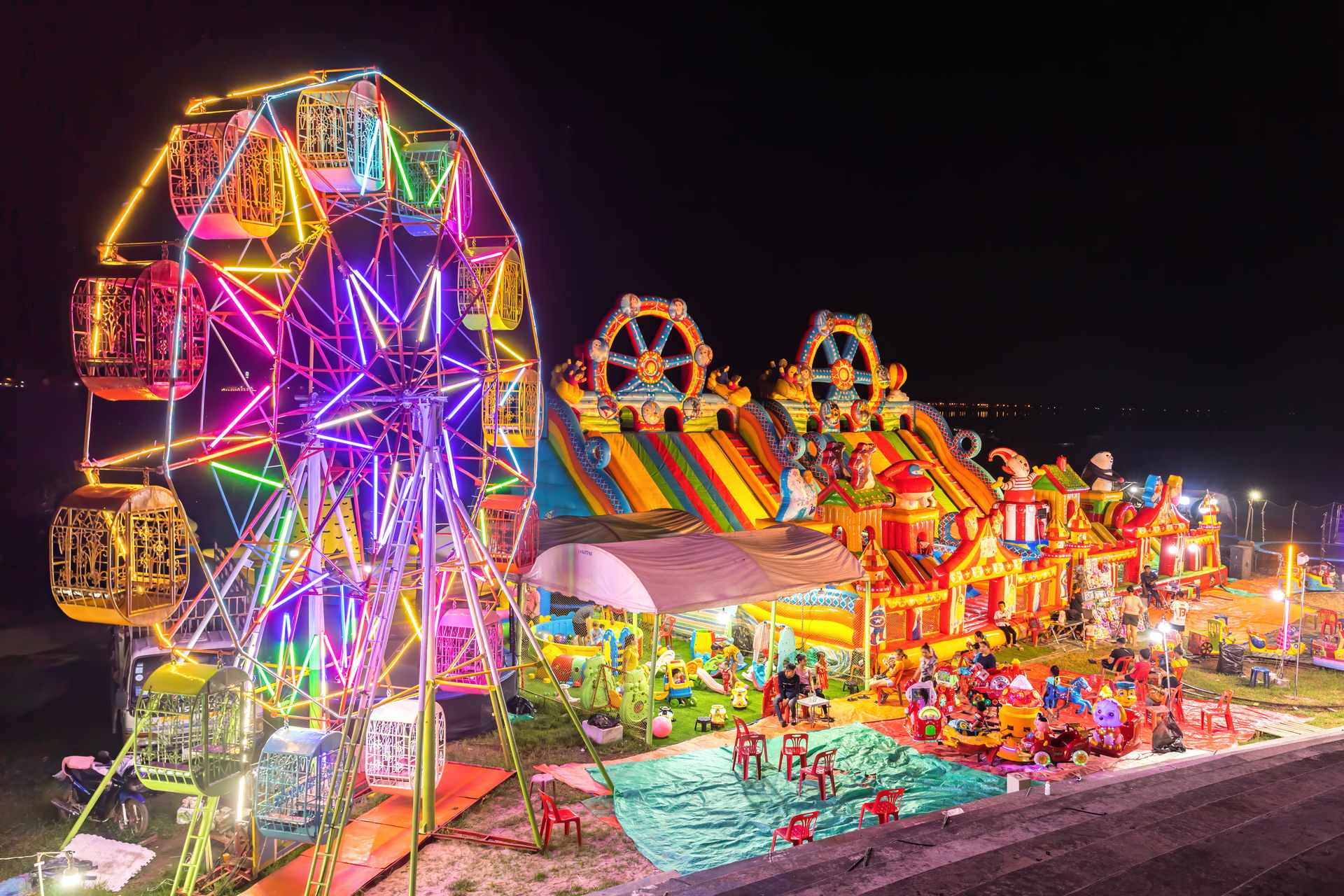 Illuminated Ferris wheel, Inflatable bouncing castle and carous…