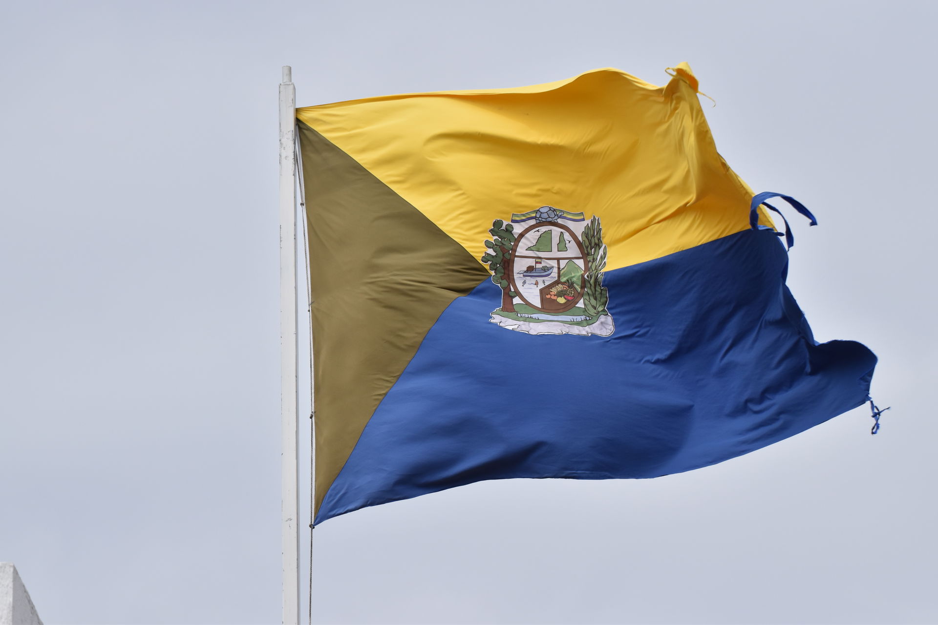 Flag of Puerto Baquerizo Moreno on the waterfront on Galapagos …
