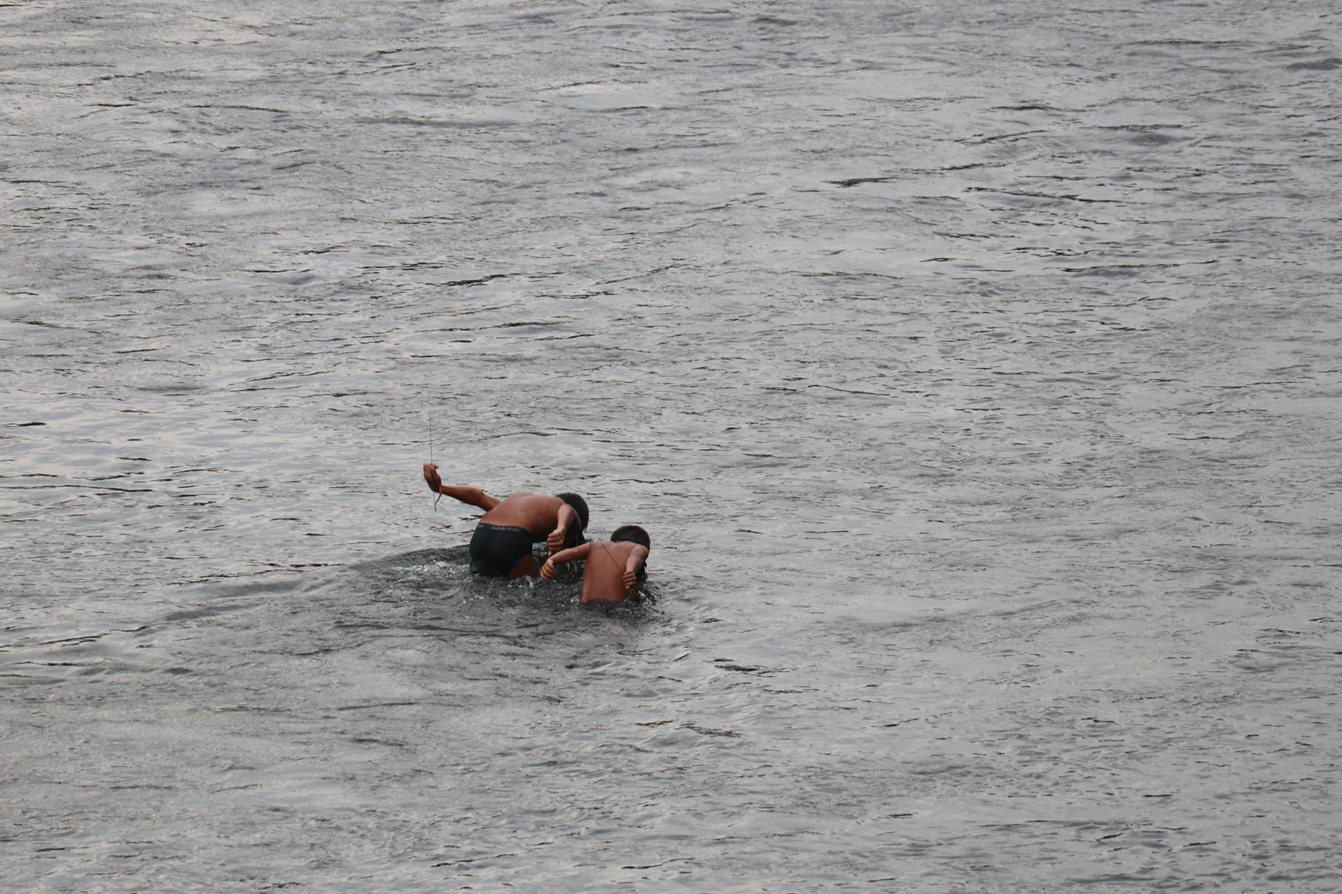 Two boy fishing in a river in Putao region. They wear diving go…