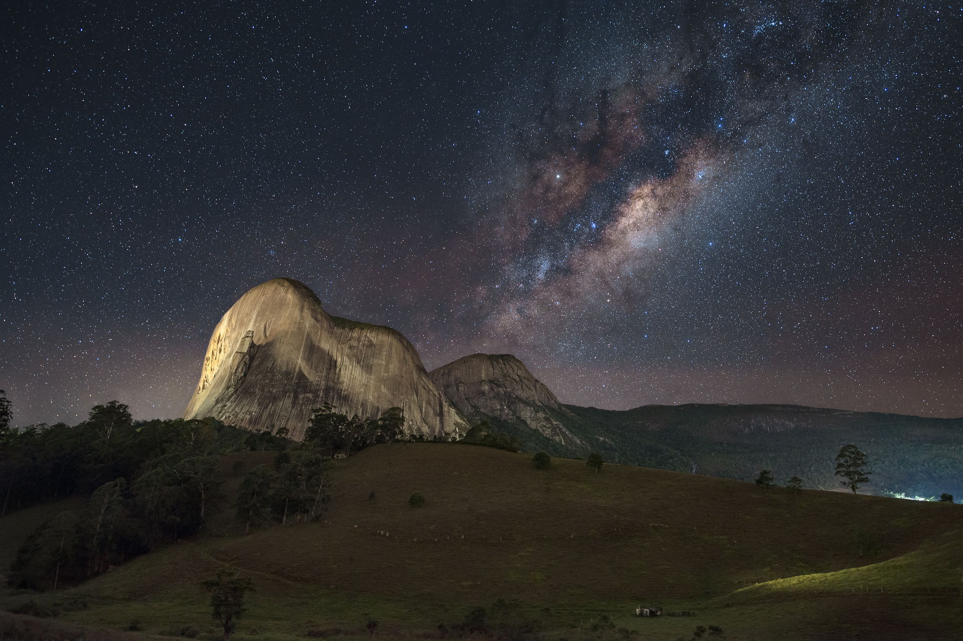 Pedra Azul (Blue Stone) peak with the center of the Milky Way a…