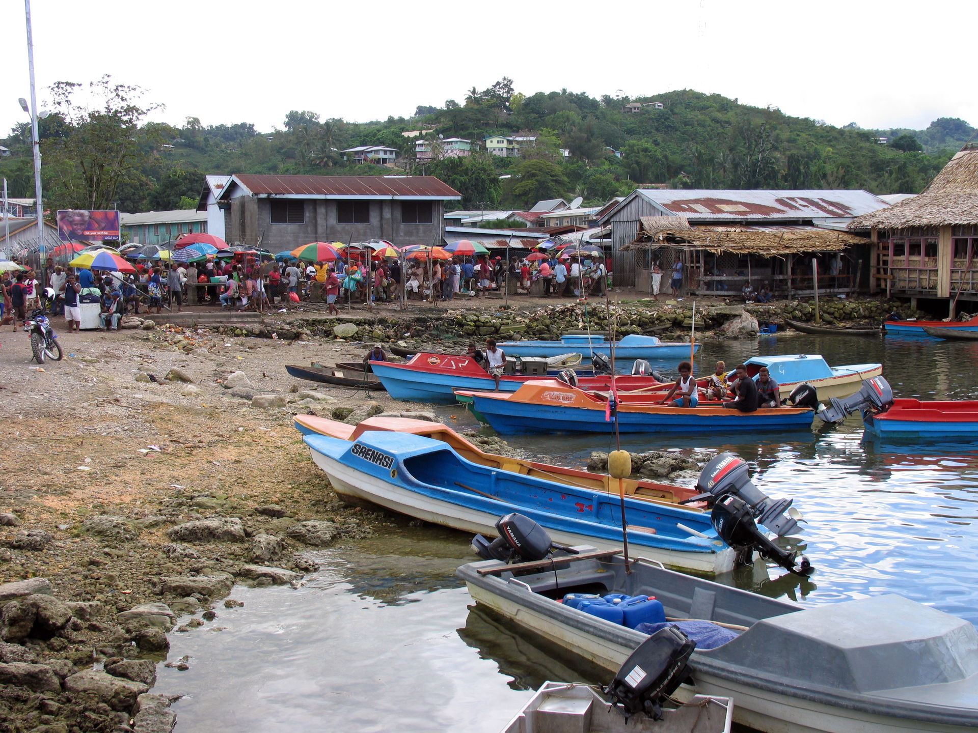 People transport goods from OBM boats to the old market in Auki…