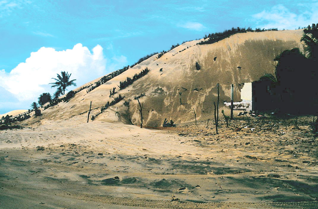 Dune advancing over a house. Acaraú, Ceará, Brazil