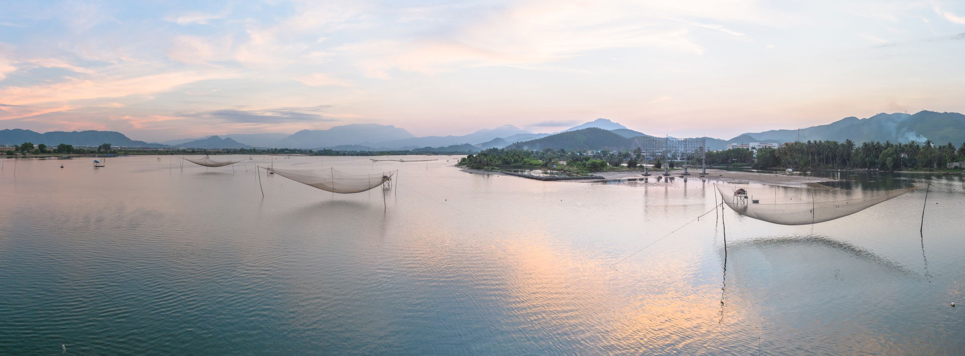 Hanging fishing nets in the Cu Đê river, just before it merges …