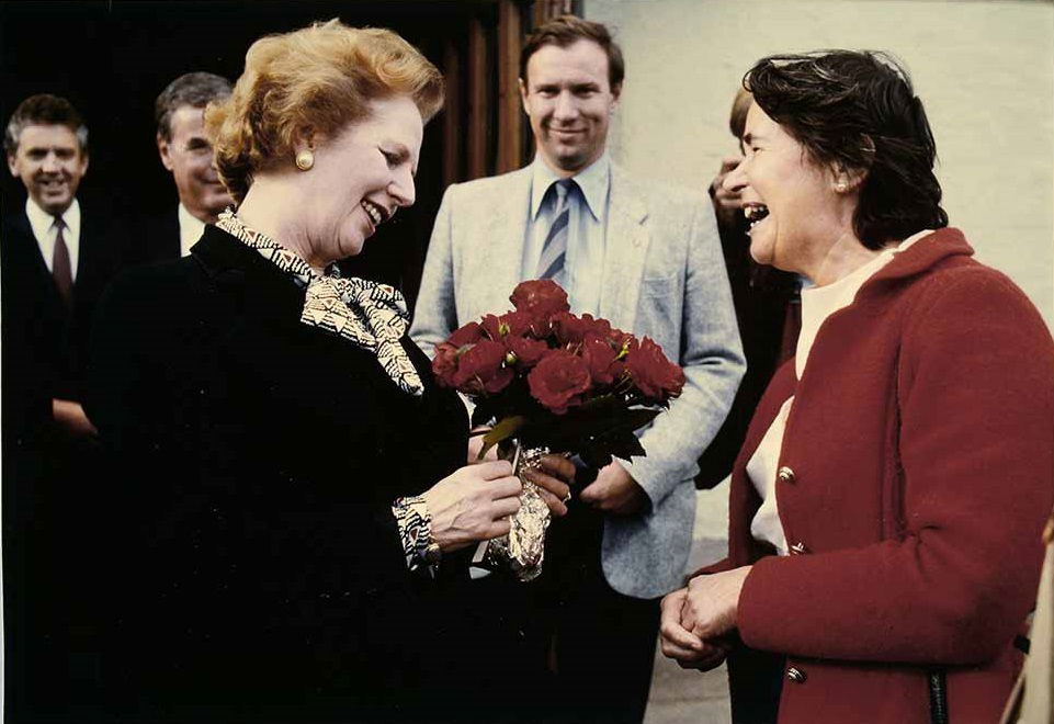 Margaret Thatcher being presented with a bunch of flowers.