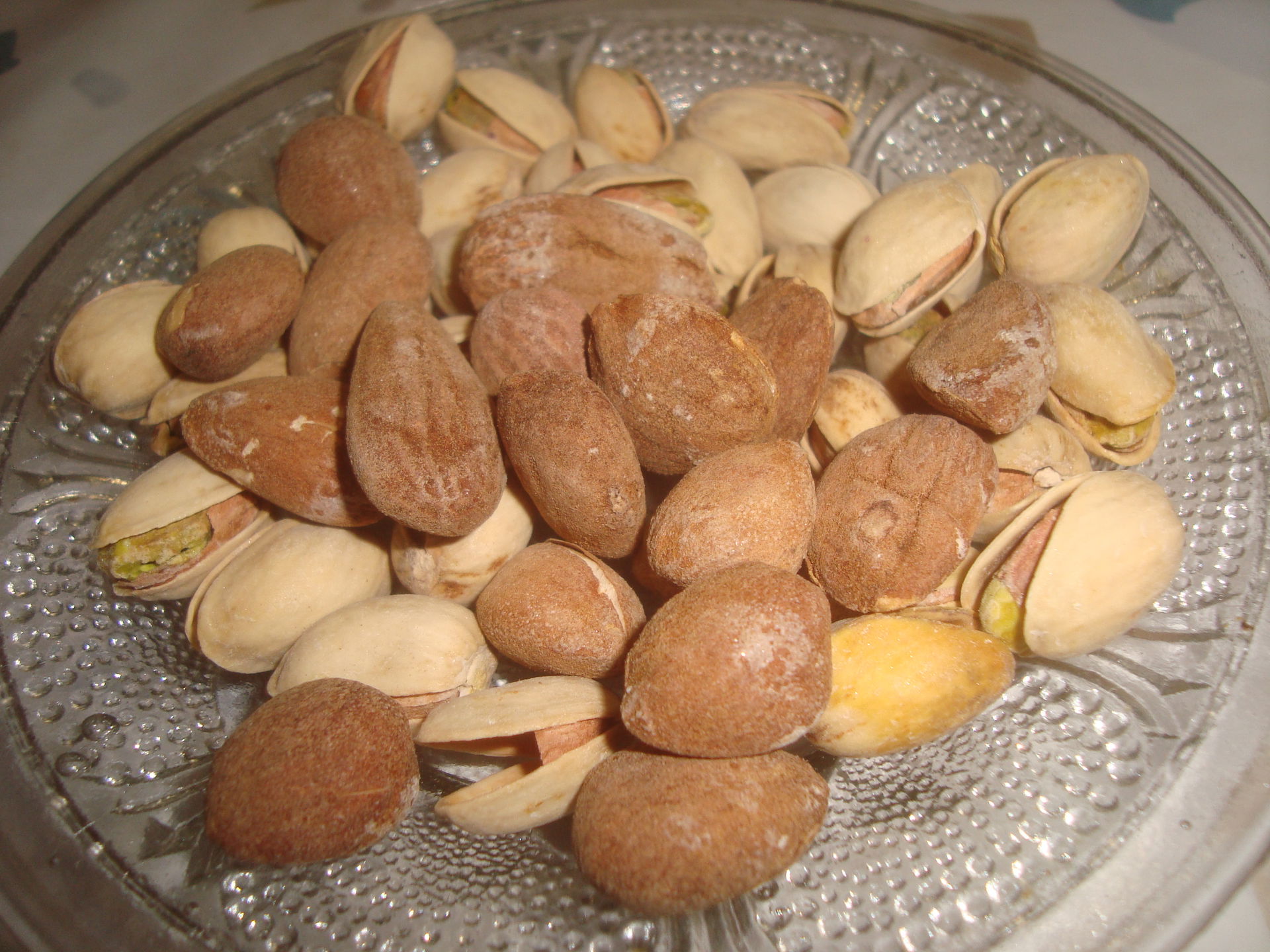 Tapa-aperitivo de frutos secos, almendras y pistachos.