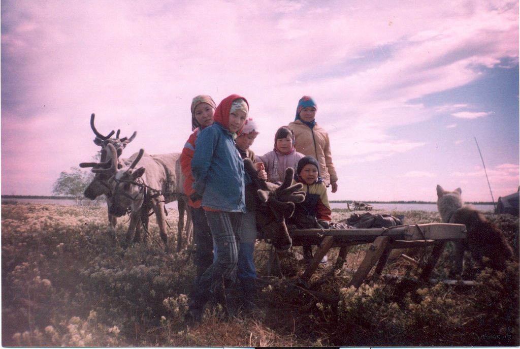 Khanty children pose for the camera in front of a reindeer sled…