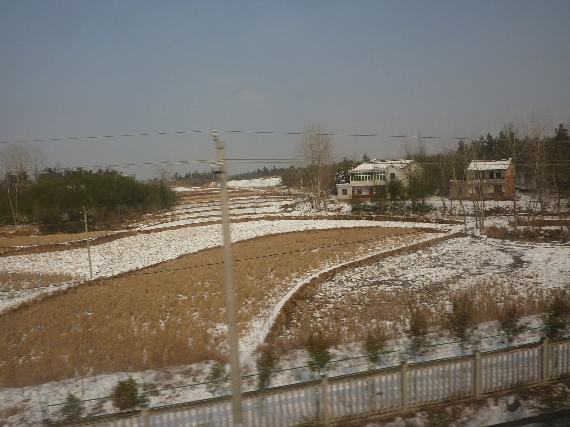 Farmers' fields, partly covered by snow, on the flatland (east …