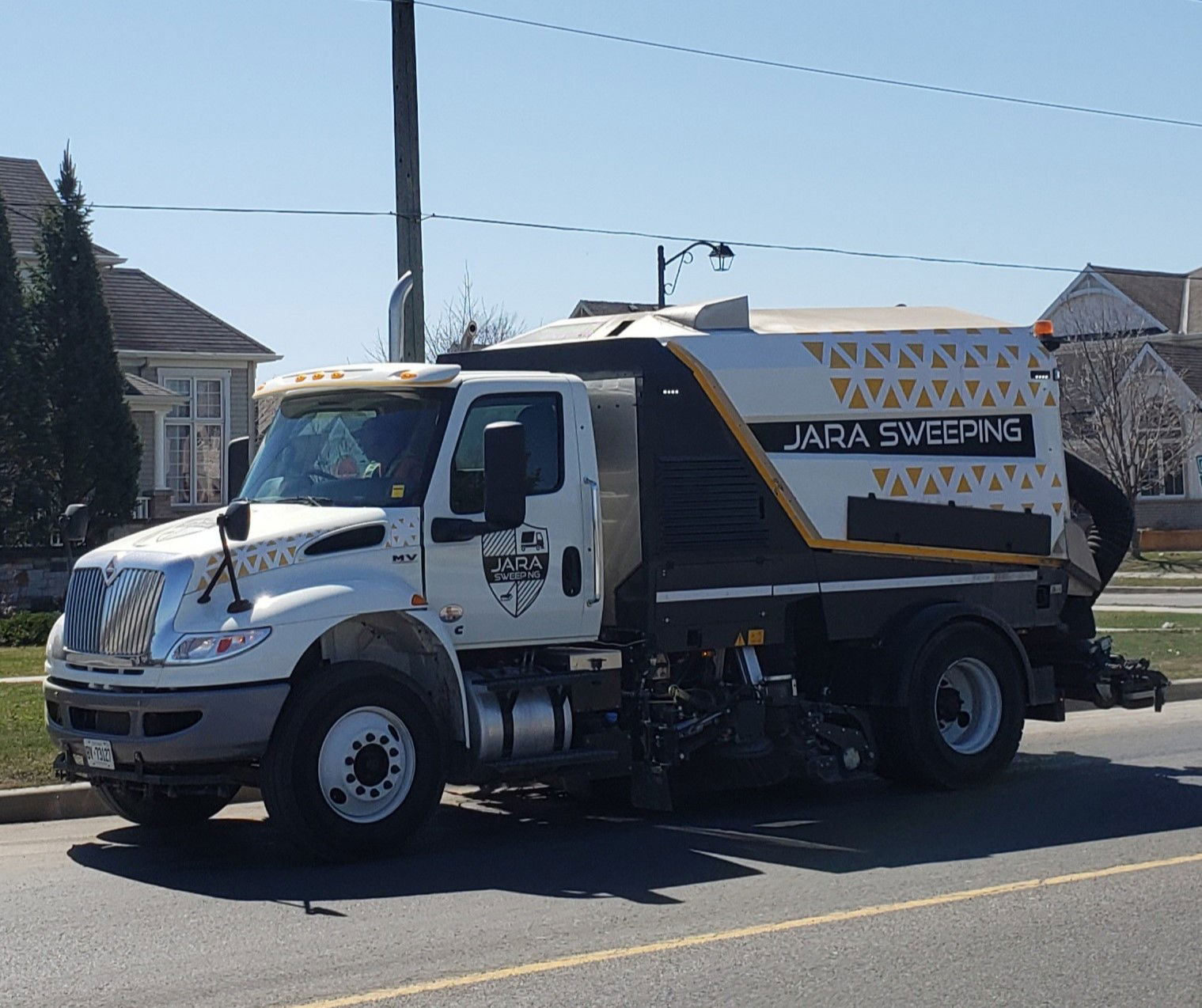 A street sweeper truck operated by a private street sweeping co…