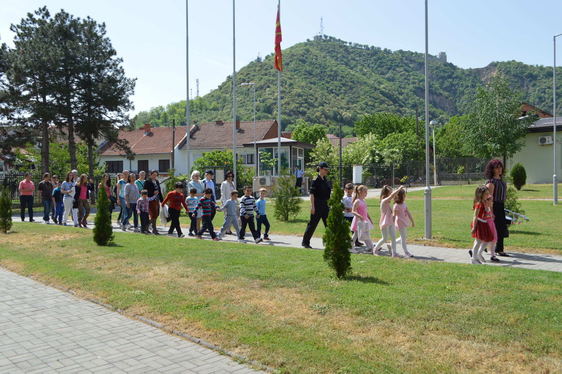 Female police officers and teachers lead a group of kids in the…