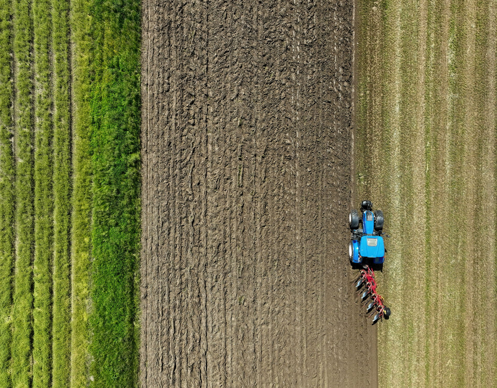 Aerial view of tractor New Holland T6.165 plowing (ploughing) a…