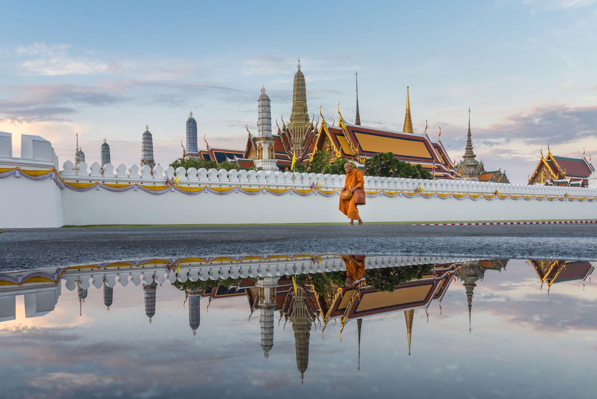 Monk walks in the morning after the rain in front of the Temple…