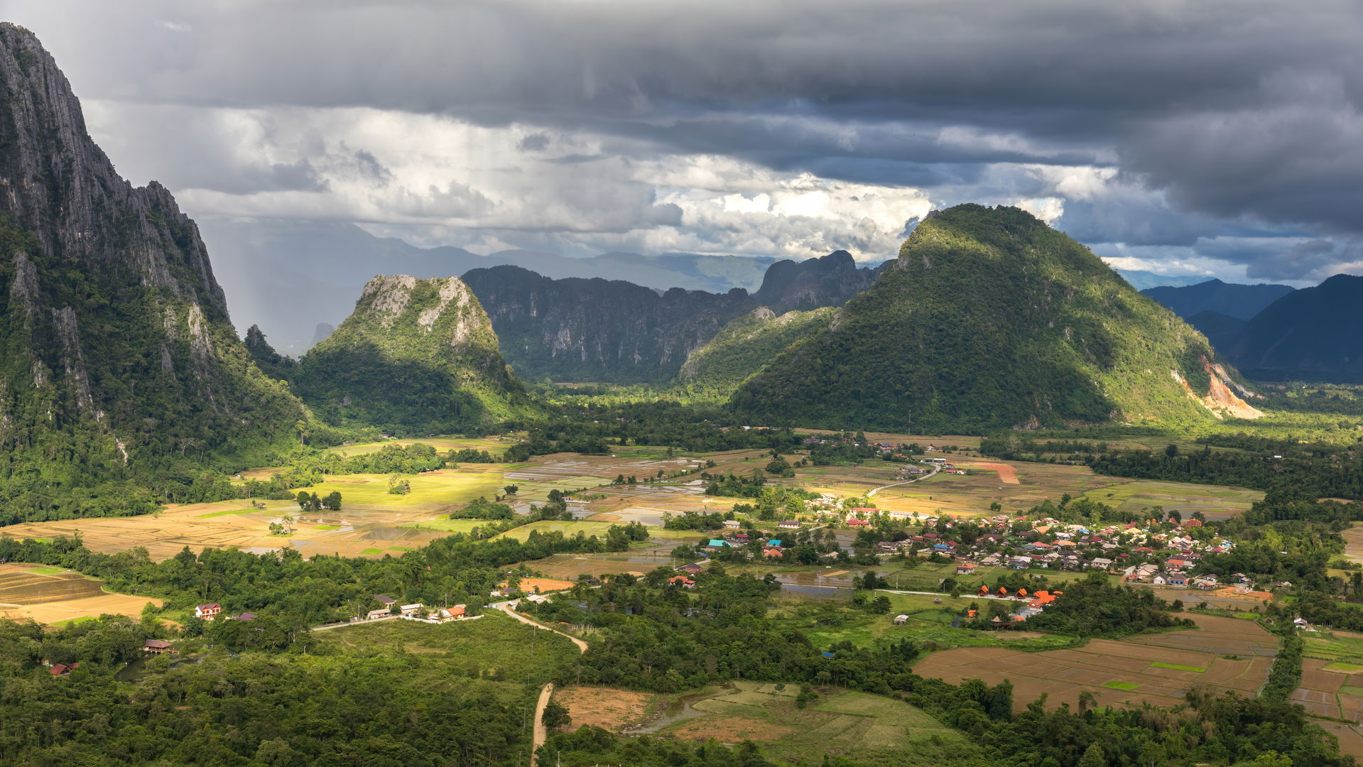 Karst peaks and green paddy fields under a stormy sky, South vi…