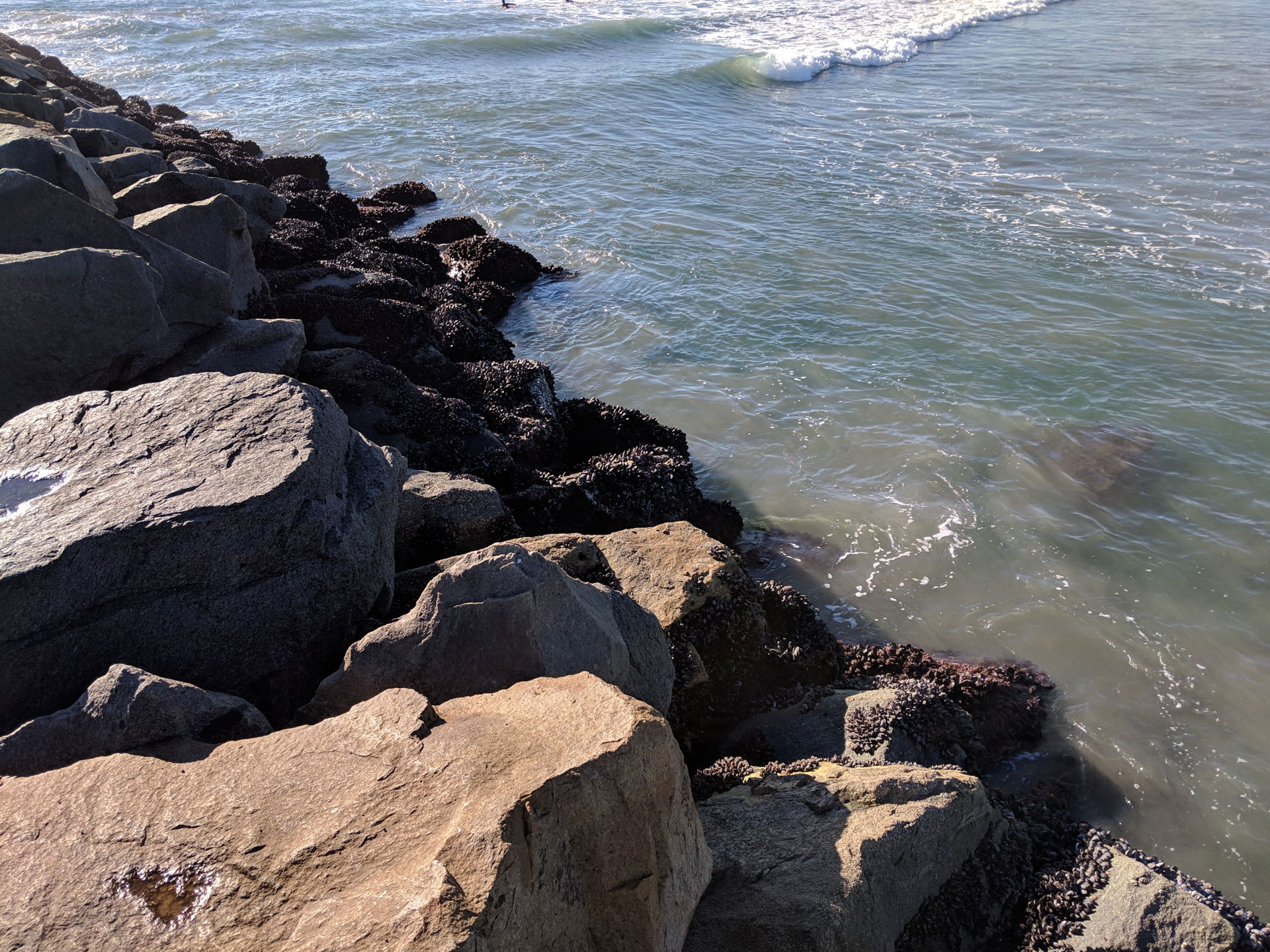 An elevated rocky path jutting out into the Pacific Ocean from …