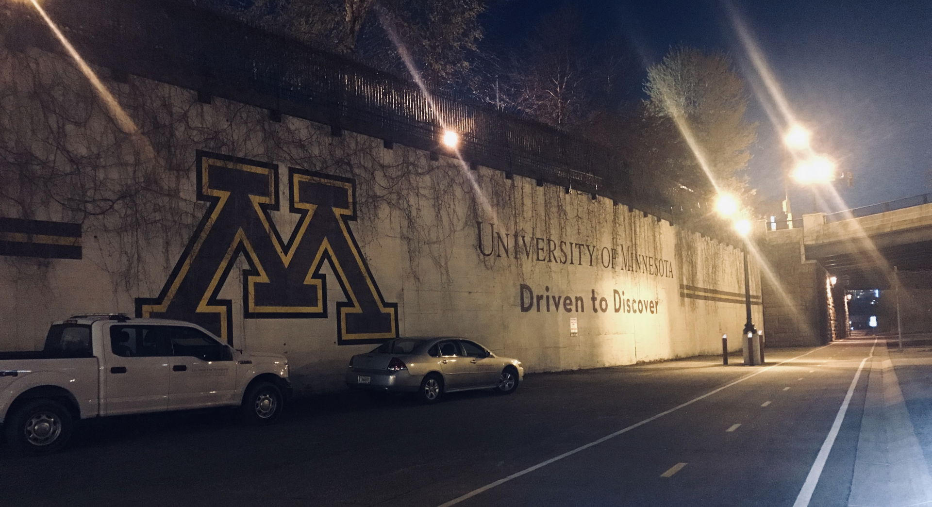 Dinkytown Greenway at night showing the lit bike path and a UMN…