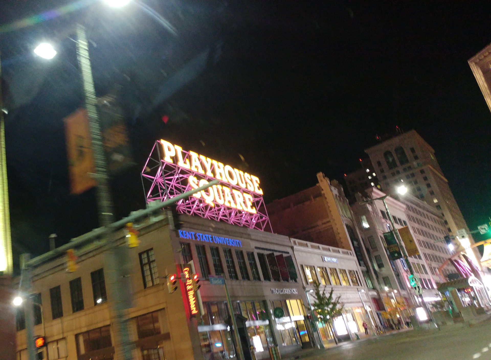 An electrically lit sign reading "Playhouse Square" at night in…