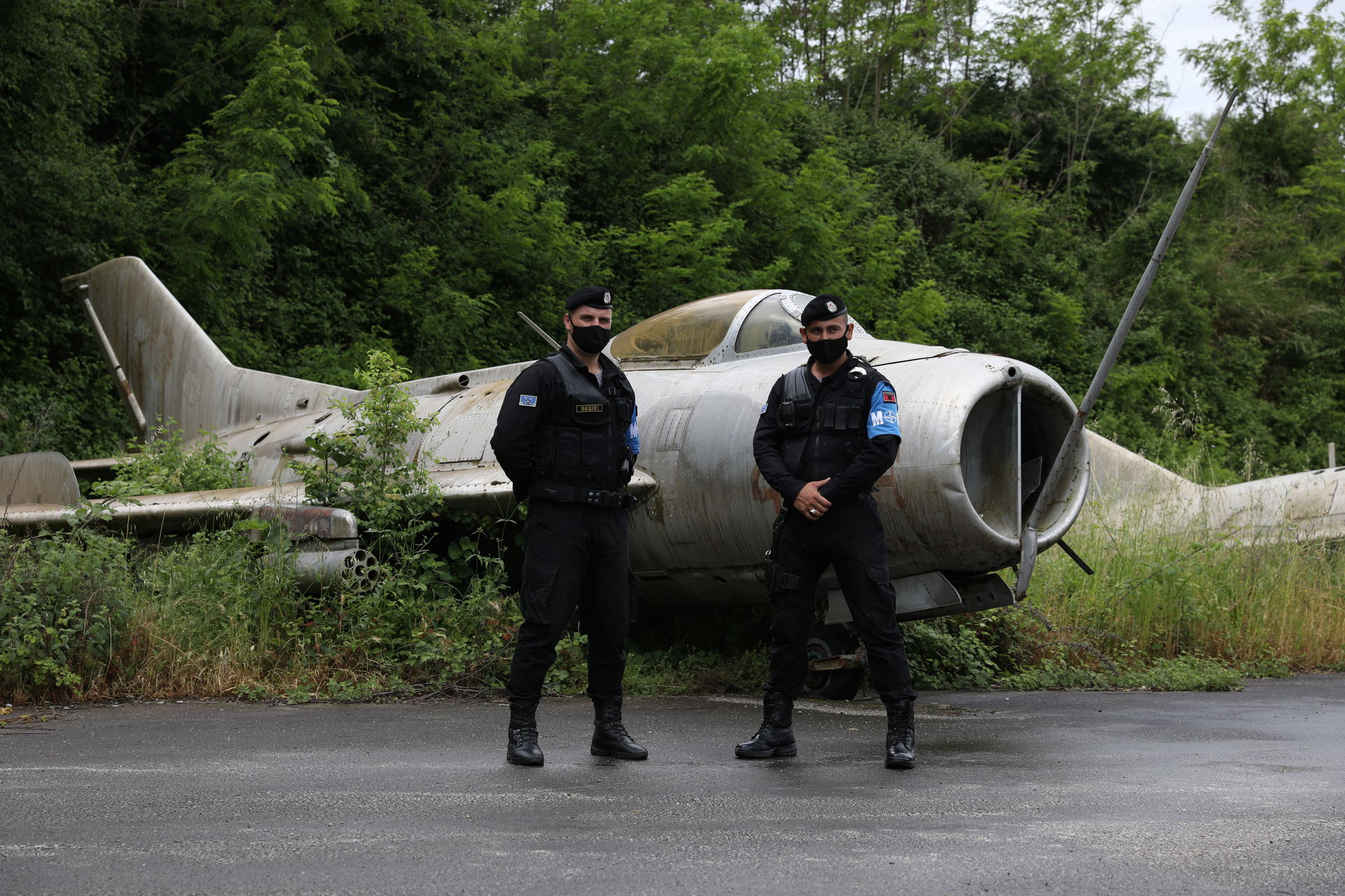 Albanian Military Police stand beside a decommissioned plane ou…